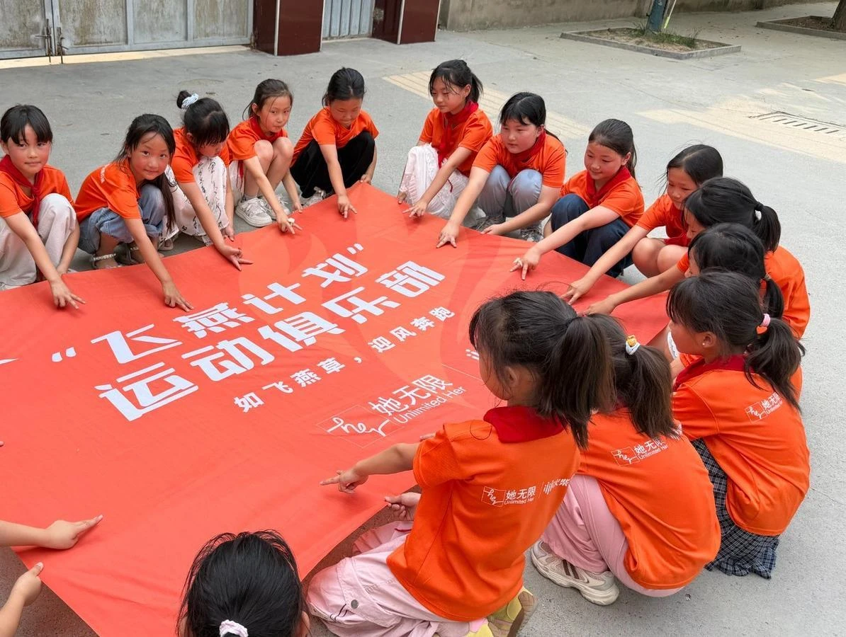 Girls gathered around a Larkspur Project banner in China